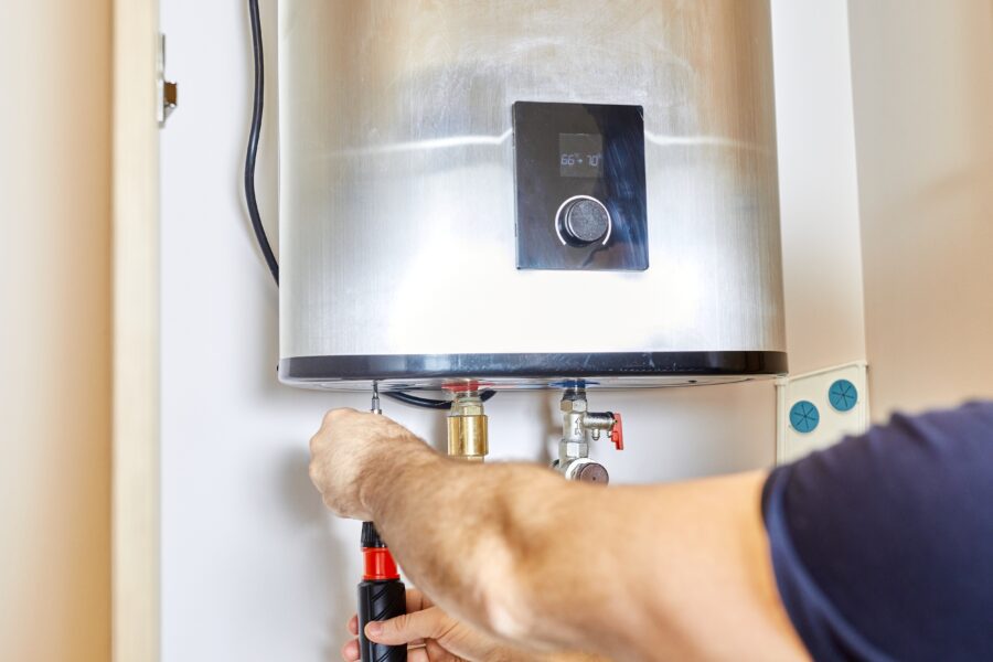 Man,Tightens,The,Pipe,Nut,In,The,Water,Heating,System.